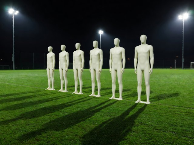 Training mannequins set up as a free-kick wall on a floodlit practice pitch